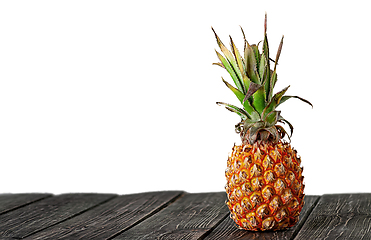 Image showing Pineapple stands on wooden boards isolated on white