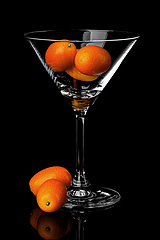 Image showing Ripe kumquat in martini glass with reflection