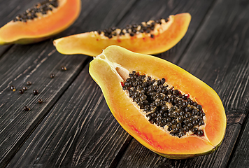 Image showing Several pieces of ripe papaya on a wooden table