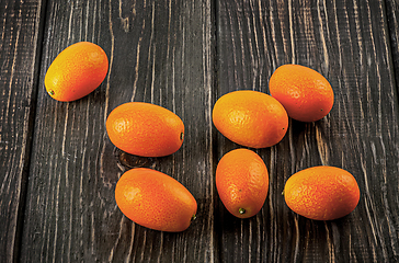 Image showing Several ripe kumquats on a wooden table