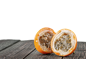 Image showing Two halves of tamarillo on wooden table