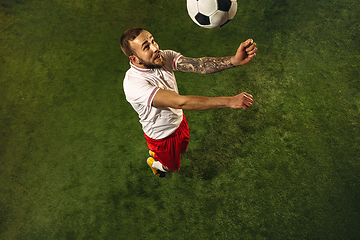 Image showing Top view of caucasian football or soccer player on green background of grass