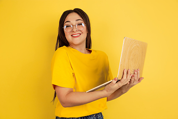 Image showing Caucasian woman\'s portrait isolated on yellow studio background