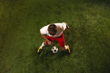 Image showing Top view of caucasian football or soccer player on green background of grass