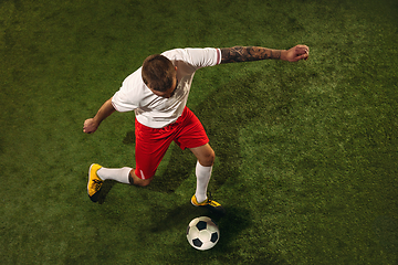 Image showing Top view of caucasian football or soccer player on green background of grass