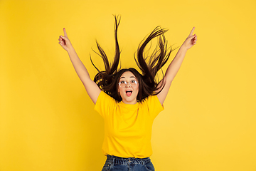 Image showing Caucasian woman\'s portrait isolated on yellow studio background