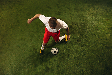 Image showing Top view of caucasian football or soccer player on green background of grass