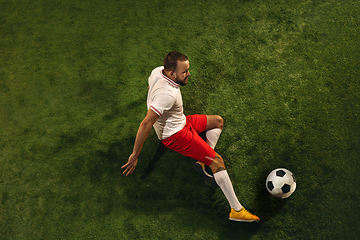 Image showing Top view of caucasian football or soccer player on green background of grass