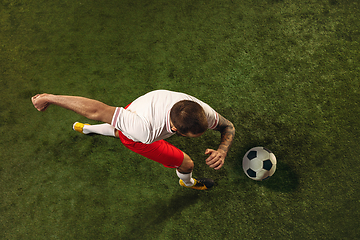 Image showing Top view of caucasian football or soccer player on green background of grass