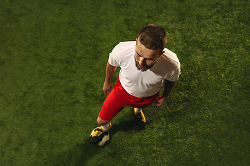 Image showing Top view of caucasian football or soccer player on green background of grass