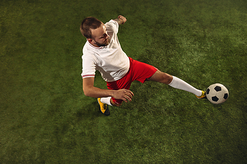 Image showing Top view of caucasian football or soccer player on green background of grass