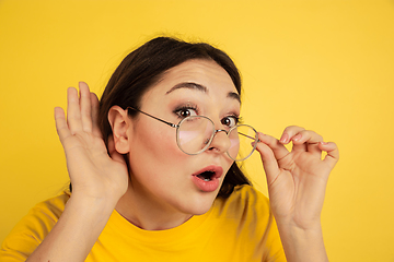 Image showing Caucasian woman\'s portrait isolated on yellow studio background