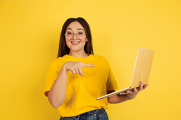 Image showing Caucasian woman\'s portrait isolated on yellow studio background