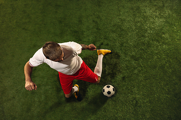 Image showing Top view of caucasian football or soccer player on green background of grass