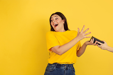 Image showing Caucasian woman\'s portrait isolated on yellow studio background