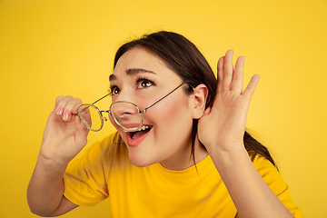 Image showing Caucasian woman\'s portrait isolated on yellow studio background