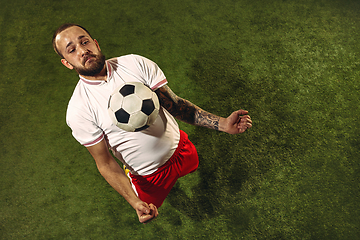 Image showing Top view of caucasian football or soccer player on green background of grass