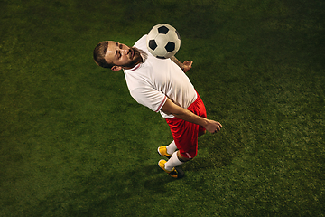 Image showing Top view of caucasian football or soccer player on green background of grass