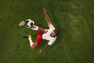 Image showing Top view of caucasian football or soccer player on green background of grass