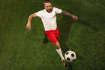 Image showing Top view of caucasian football or soccer player on green background of grass