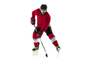 Image showing Male hockey player with the stick on ice court and white background