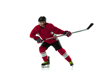 Image showing Male hockey player with the stick on ice court and white background