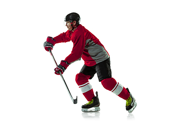 Image showing Male hockey player with the stick on ice court and white background