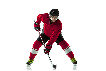 Image showing Male hockey player with the stick on ice court and white background