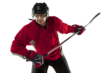 Image showing Male hockey player with the stick on ice court and white background