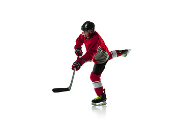 Image showing Male hockey player with the stick on ice court and white background