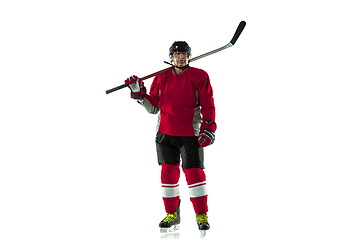 Image showing Male hockey player with the stick on ice court and white background