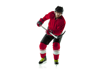 Image showing Male hockey player with the stick on ice court and white background