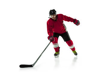 Image showing Male hockey player with the stick on ice court and white background