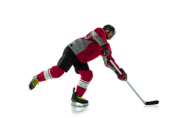 Image showing Male hockey player with the stick on ice court and white background