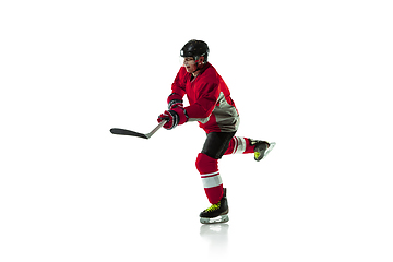 Image showing Male hockey player with the stick on ice court and white background