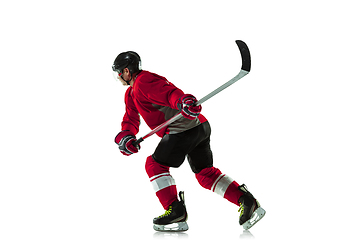 Image showing Male hockey player with the stick on ice court and white background