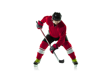 Image showing Male hockey player with the stick on ice court and white background