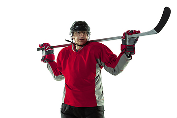 Image showing Male hockey player with the stick on ice court and white background