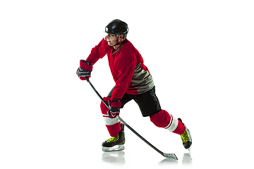 Image showing Male hockey player with the stick on ice court and white background