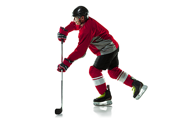 Image showing Male hockey player with the stick on ice court and white background