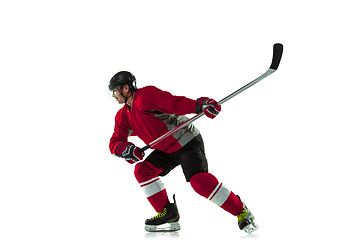 Image showing Male hockey player with the stick on ice court and white background