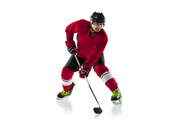 Image showing Male hockey player with the stick on ice court and white background