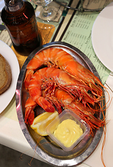 Image showing Jumbo shrimps with lemon and sauce on metal plate