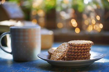 Image showing Teacup and Christmas gluten free cookies on a table near the win