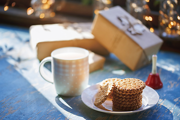 Image showing Teacup and Christmas gluten free cookies on a table near the dec