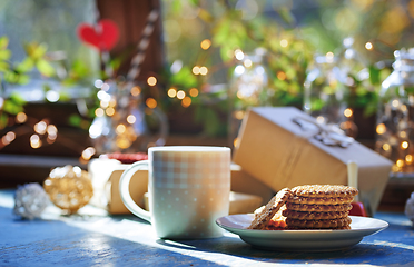 Image showing Teacup and Christmas gluten free cookies on a table near the dec