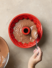 Image showing putting chocolate cake dough in silicone baking form