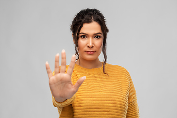 Image showing woman showing stop gesture over grey background