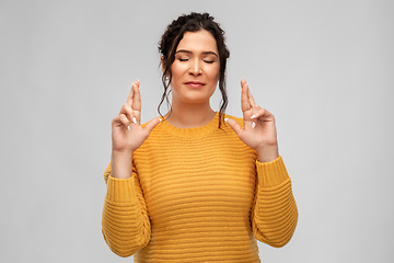 Image showing woman with pierced nose holding fingers crossed