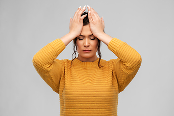 Image showing stressed young woman holding to her head